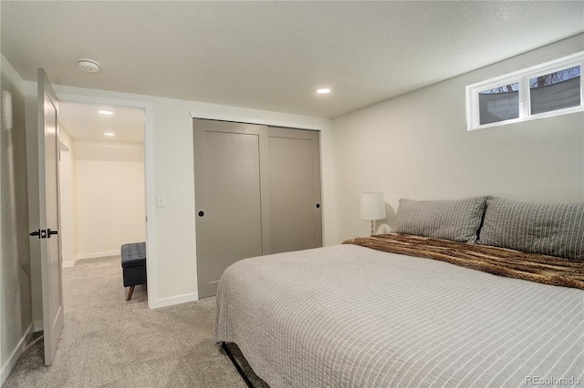 bedroom featuring baseboards, a closet, recessed lighting, and light colored carpet