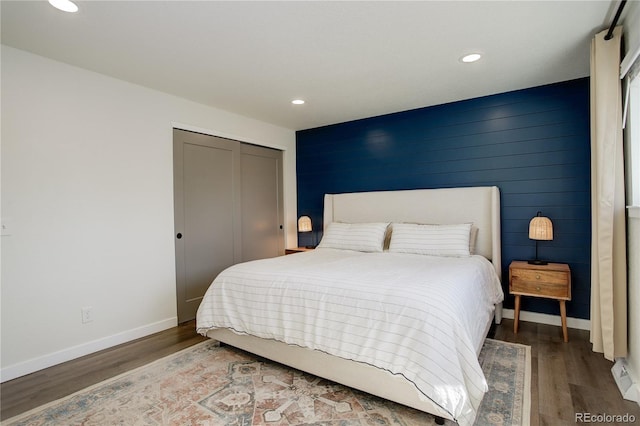 bedroom featuring a closet, baseboards, wood finished floors, and recessed lighting