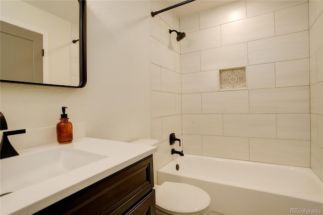 bathroom featuring washtub / shower combination, vanity, and toilet