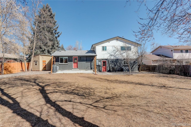 view of front of property with an outbuilding, a storage shed, and fence