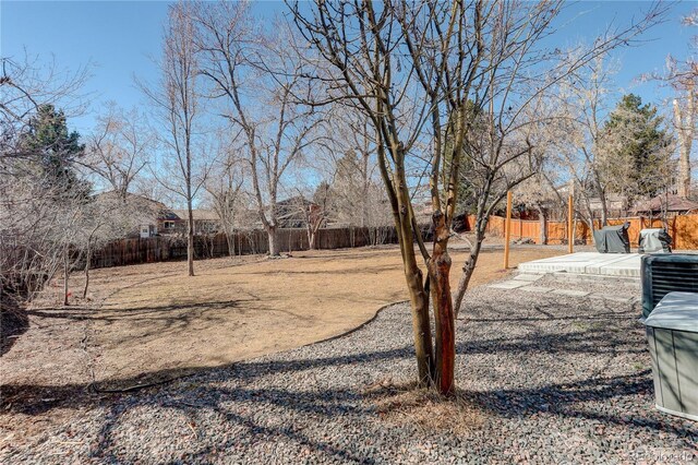 view of yard featuring a fenced backyard, a patio, and central AC