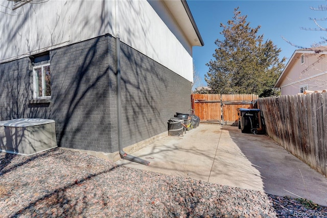 view of home's exterior with a gate, a patio, and fence