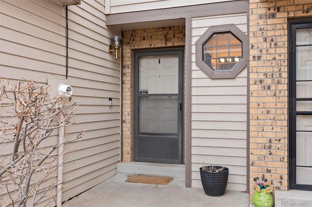 property entrance featuring brick siding