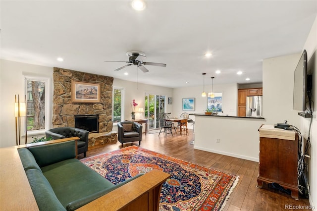 living room featuring recessed lighting, ceiling fan, dark wood-type flooring, and a fireplace