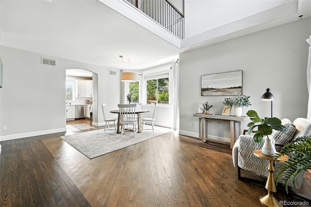 6039 Quay Ct, Arvada, CO 80003 - dining space with arched walkways, plenty of natural light, and dark wood-style flooring