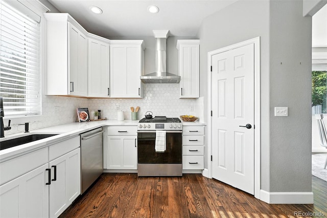 6039 Quay Ct, Arvada, CO 80003 - kitchen featuring appliances with stainless steel finishes, wall chimney exhaust hood, decorative backsplash, dark wood-style floors, and recessed lighting