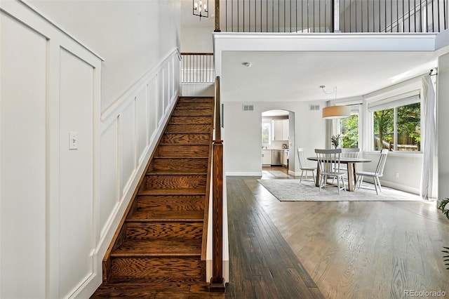 6039 Quay Ct, Arvada, CO 80003 - staircase featuring arched walkways, wood finished floors, and a decorative wall
