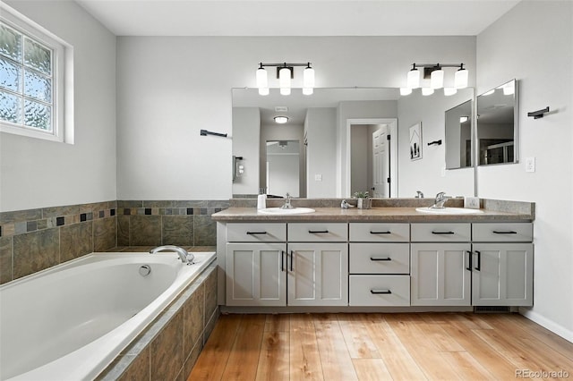 6039 Quay Ct, Arvada, CO 80003 - bathroom featuring double vanity, a garden tub, and wood finished floors