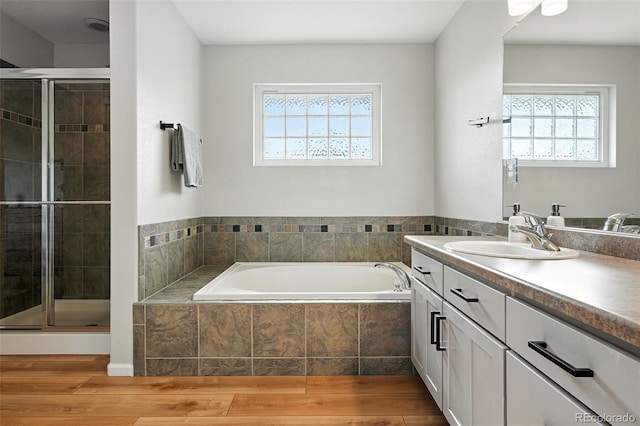 6039 Quay Ct, Arvada, CO 80003 - bathroom featuring vanity, plenty of natural light, a bath, and wood finished floors