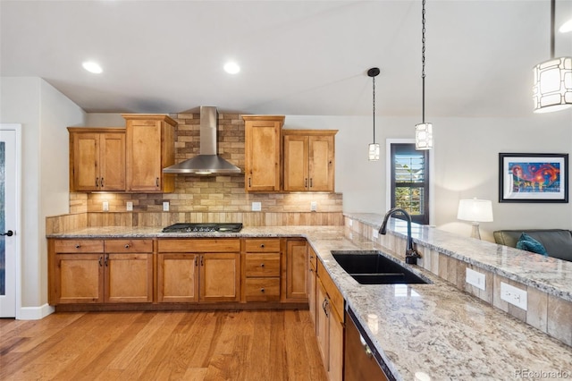 12441 Woodruff Dr, Colorado Springs, CO 80921 - kitchen featuring a sink, wall chimney range hood, appliances with stainless steel finishes, tasteful backsplash, and light wood-style flooring