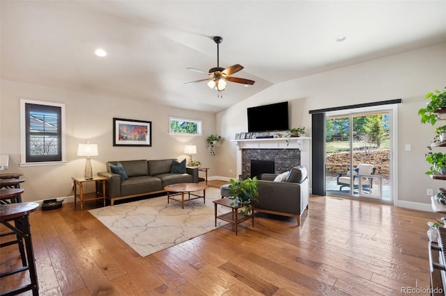 12441 Woodruff Dr, Colorado Springs, CO 80921 - living room with vaulted ceiling, a ceiling fan, a fireplace, hardwood / wood-style flooring, and baseboards