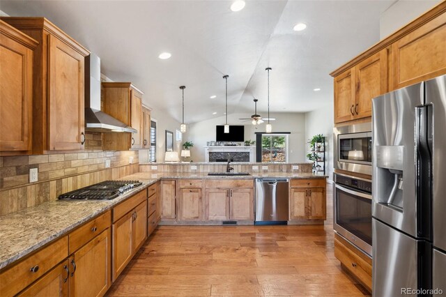 12441 Woodruff Dr, Colorado Springs, CO 80921 - kitchen with appliances with stainless steel finishes, a sink, wall chimney exhaust hood, ceiling fan, and backsplash