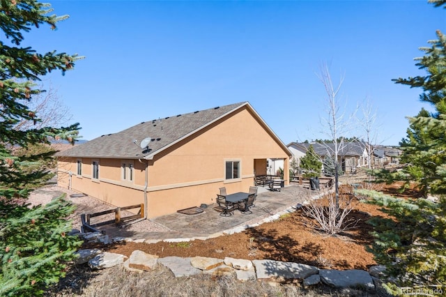 12441 Woodruff Dr, Colorado Springs, CO 80921 - back of property featuring stucco siding, a patio, and a shingled roof