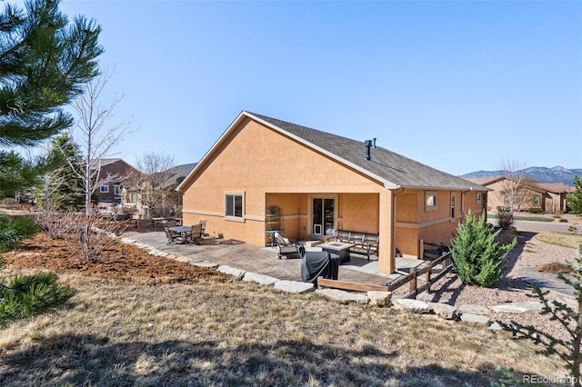 12441 Woodruff Dr, Colorado Springs, CO 80921 - back of house featuring a patio, stucco siding, an outdoor fire pit, and a mountain view