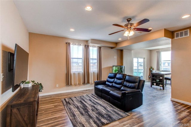 living room with baseboards, visible vents, dark wood finished floors, and recessed lighting