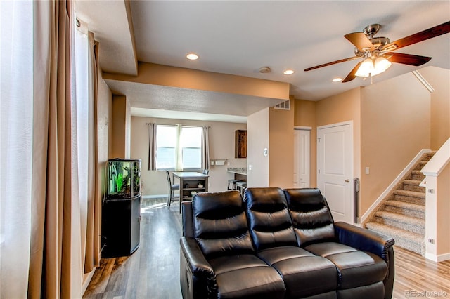 living room featuring light wood-style flooring, recessed lighting, visible vents, baseboards, and stairs