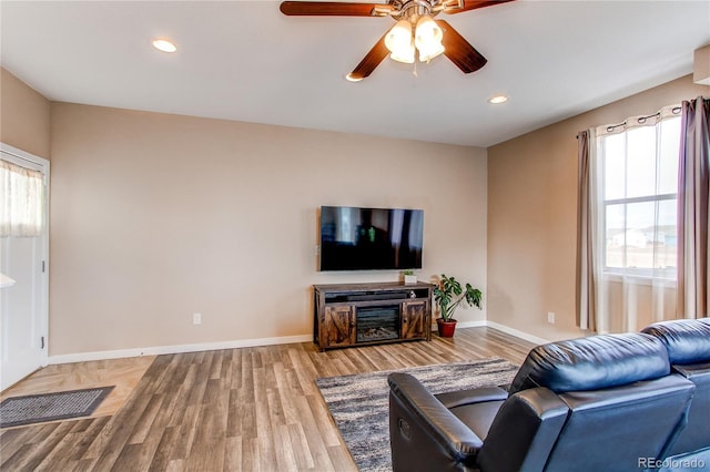 living area with recessed lighting, wood finished floors, a ceiling fan, and baseboards