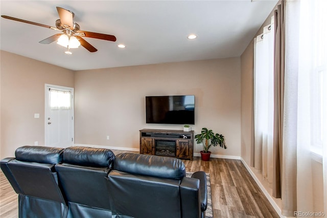 living area featuring recessed lighting, wood finished floors, a ceiling fan, and baseboards