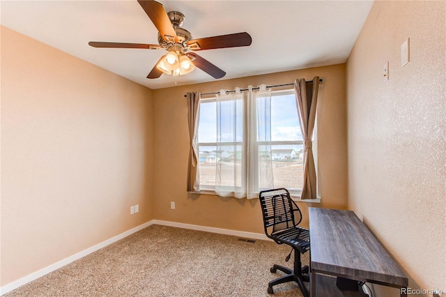 carpeted office space featuring a ceiling fan, visible vents, and baseboards