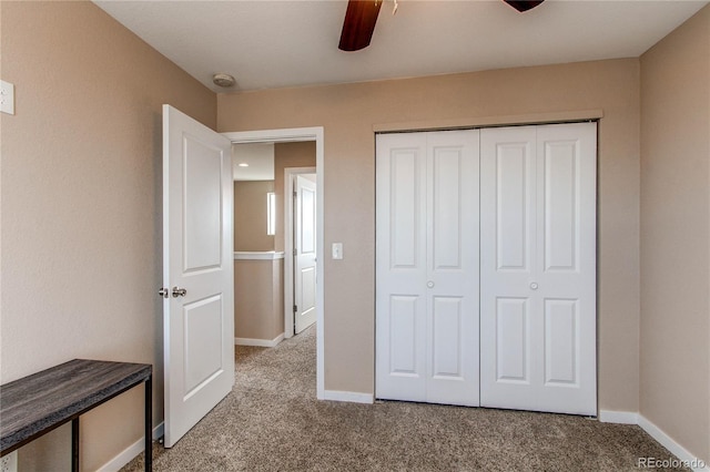 unfurnished bedroom with a ceiling fan, baseboards, a closet, and light colored carpet