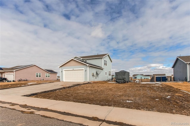 view of side of home with a garage, a residential view, and concrete driveway