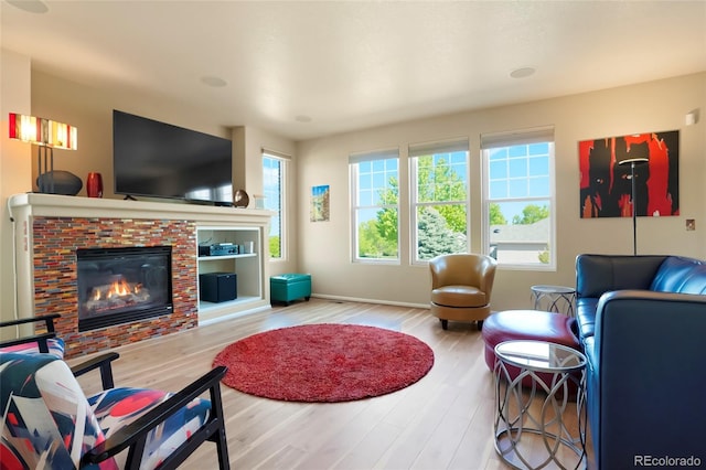21395 E Greenwood Pl, Aurora, CO 80013 - living room featuring wood finished floors, a brick fireplace, and baseboards