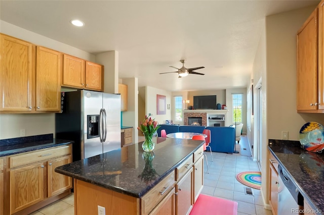 21395 E Greenwood Pl, Aurora, CO 80013 - kitchen with stainless steel appliances, light tile patterned floors, a glass covered fireplace, ceiling fan, and a kitchen island