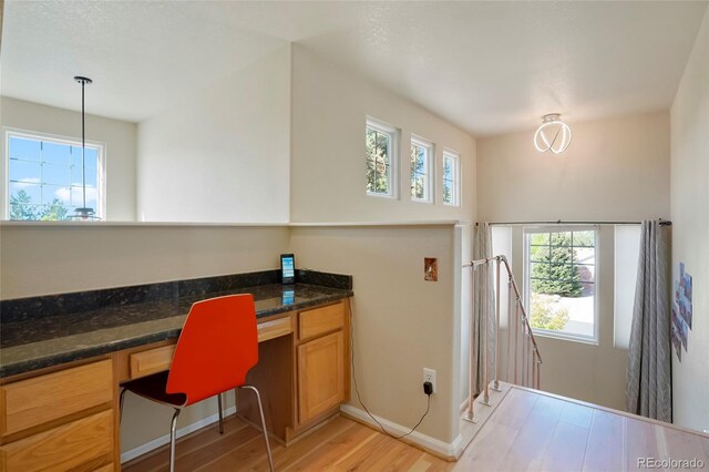 21395 E Greenwood Pl, Aurora, CO 80013 - office area featuring built in study area, plenty of natural light, light wood-style floors, and baseboards