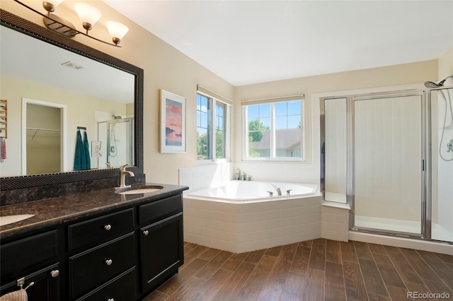 21395 E Greenwood Pl, Aurora, CO 80013 - bathroom with a stall shower, wood finished floors, a garden tub, double vanity, and a walk in closet