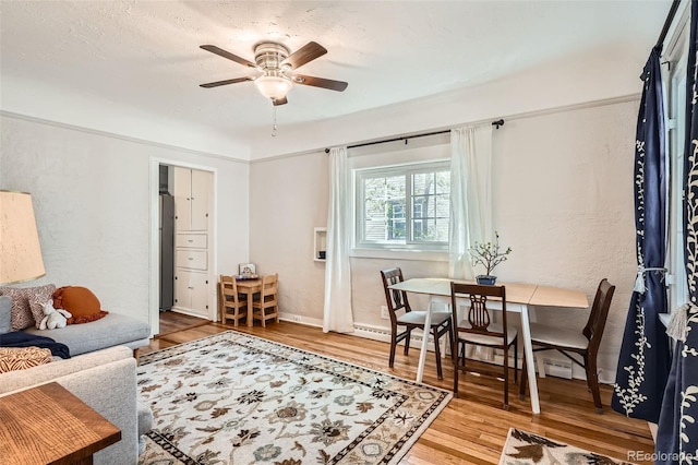 living room with baseboards, ceiling fan, and wood finished floors