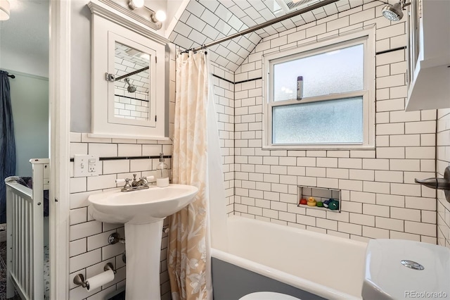 full bathroom featuring visible vents, tile walls, shower / bath combo, and tasteful backsplash