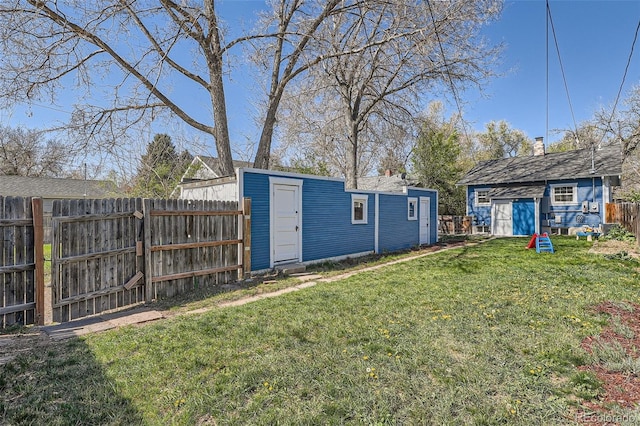 view of yard featuring an outbuilding, a fenced backyard, and a storage unit