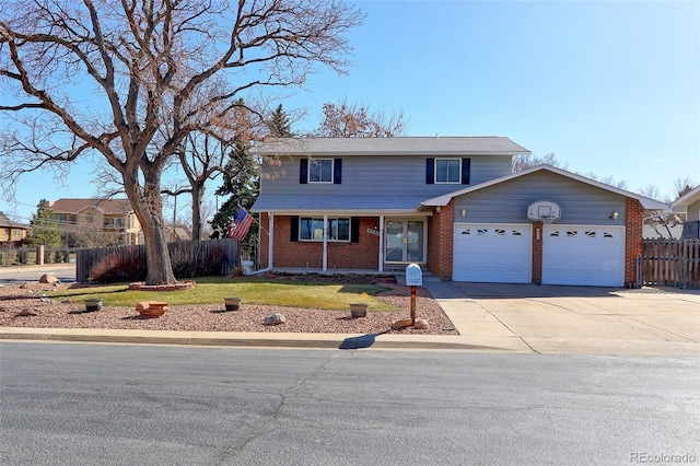 traditional-style home with driveway, fence, a front yard, a garage, and brick siding