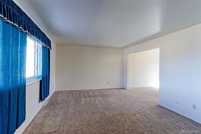 spare room featuring visible vents and carpet floors