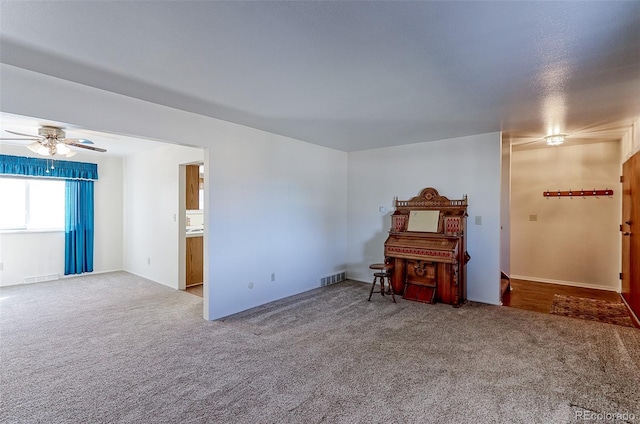 interior space with visible vents, a ceiling fan, and carpet floors