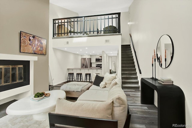 8055 E Colorado Ave Unit 8, Denver, CO 80231 - living area with stairs, a high ceiling, a glass covered fireplace, and wood finished floors