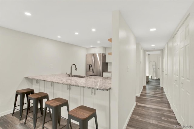 8055 E Colorado Ave Unit 8, Denver, CO 80231 - kitchen featuring stainless steel fridge with ice dispenser, dark wood finished floors, a kitchen bar, a peninsula, and recessed lighting
