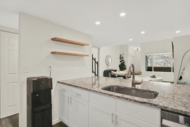 8055 E Colorado Ave Unit 8, Denver, CO 80231 - kitchen with stainless steel dishwasher, open shelves, light stone countertops, dark wood-style flooring, and white cabinets