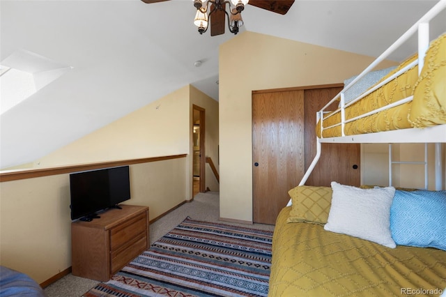 carpeted bedroom featuring vaulted ceiling, a closet, baseboards, and a skylight