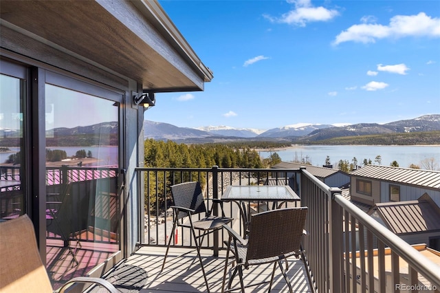 wooden terrace with a water and mountain view