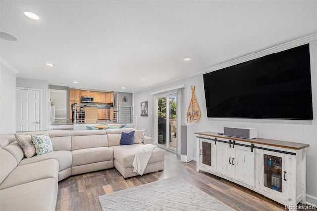 living room with recessed lighting, wood finished floors, baseboards, and ornamental molding