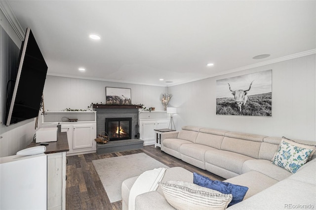 living area featuring a glass covered fireplace, recessed lighting, dark wood-type flooring, and crown molding
