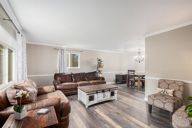 living area with an inviting chandelier, ornamental molding, dark wood-type flooring, and baseboards