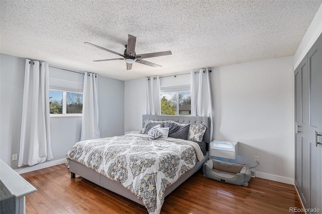 bedroom featuring wood finished floors, a textured ceiling, and multiple windows