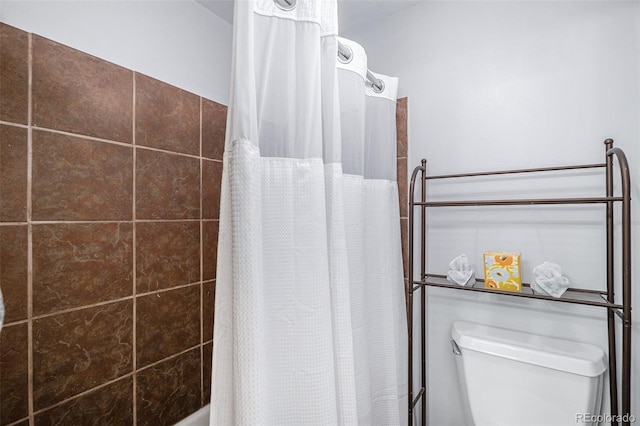 bathroom with shower / tub combo with curtain and toilet