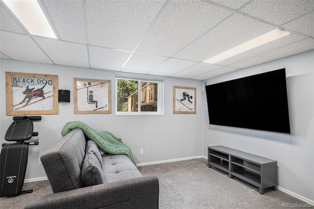 living area with baseboards, carpet flooring, and a paneled ceiling