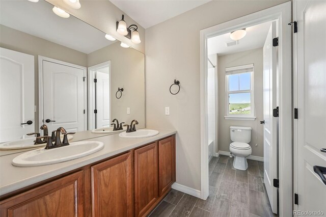 19782 W 59th Ave, Golden, CO 80403 - bathroom featuring double vanity, toilet, baseboards, wood finished floors, and  shower combination