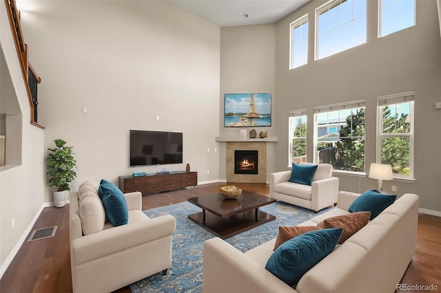 19782 W 59th Ave, Golden, CO 80403 - living area with a high ceiling, baseboards, wood finished floors, and a warm lit fireplace