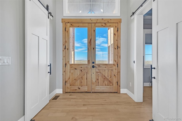 7668 Buckskin Ranch Vw, Peyton, CO 80831 - foyer with light wood-type flooring, baseboards, visible vents, and a barn door