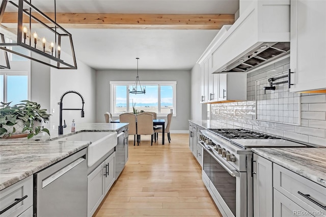 7668 Buckskin Ranch Vw, Peyton, CO 80831 - kitchen featuring dishwasher, premium range hood, beamed ceiling, a chandelier, and stainless steel range